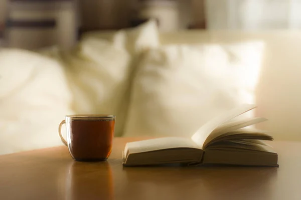 Стакан чая и книга на столе, на фоне столба — стоковое фото