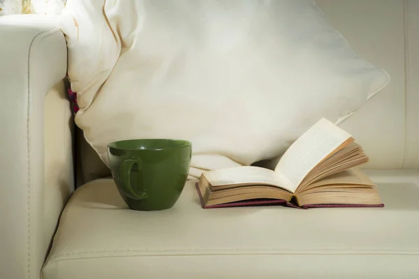 Зеленая кружка и книга, на фоне подушек на кровати — стоковое фото