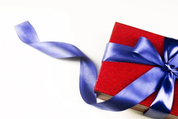Красная подарочная коробка с голубым бантом, на белом фоне — стоковое фото