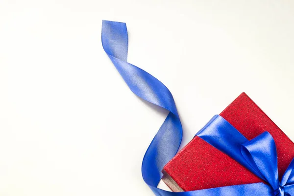 A red gift box with a blue bow, on a white background — Stock Photo, Image