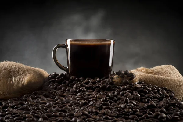 Чашка кофе на кофейных зерен с джутом — стоковое фото