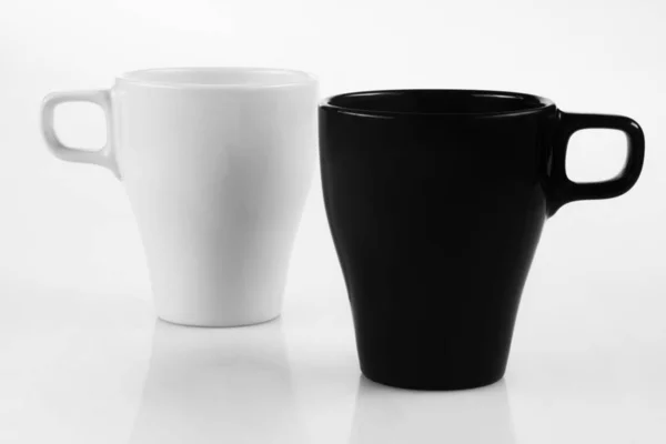 White mug and black mug on a white background — Stock Photo, Image