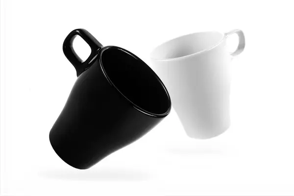 Tasse blanche et tasse noire sur fond blanc — Photo