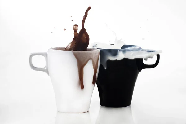 Taza blanca con café y taza negra con leche en un fondo blanco — Foto de Stock