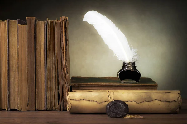 Papyrus scrolls on a table top with books, pen and inkwell