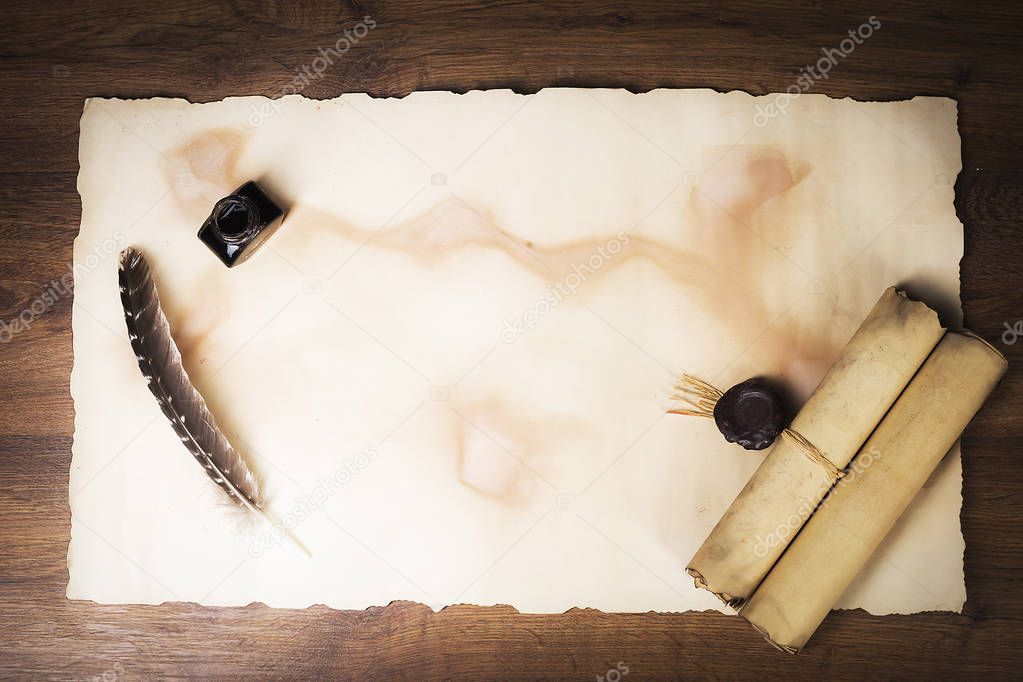 Papyrus scrolls on a table top, feather and inkwell
