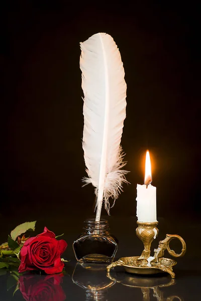 Rosa roja, pluma en el tintero y vela en el candelero o — Foto de Stock