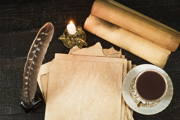 Чашка напою, сувій папірусу, пір'їна і свічки в свічці Стокове Фото