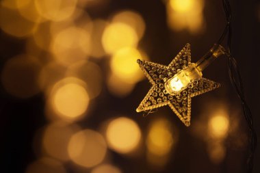 Yıldız şeklinde garland. Bulanık ışıklar. Sarı ışık