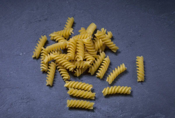 Spiral durum wheat pasta on black background