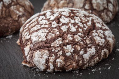 Siyah tahtada kremalı ev yapımı kekler. Arkaplanda çikolatalı kek var. Evde yemek pişir. Amerikan Çatlak Noel Kurabiyeleri