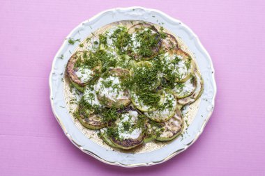 Ekşi kremalı kızarmış kabak ve bir tabakta dereotu. Yukarıdan görüntüle.