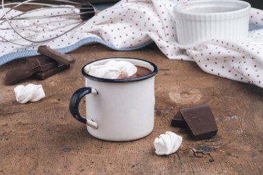 Ahşap zemin üzerinde lokum olan metal bardak sıcak çikolata..