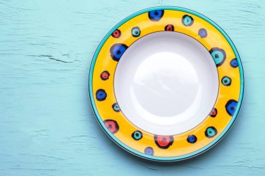 Boş tabak. Parlak renkli tabaklar. Mavi arka planda izole edilmiş. Yukarıdan görüntüle