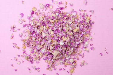 Pembe arka planda kuru çay yaprakları. Yukarıdan bak. Bitki çayı.