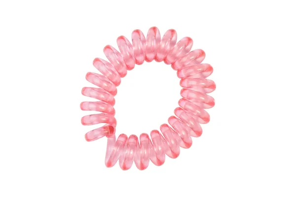 Pink spiral elastic. Elastic band for hair on a white background close-up, copy space for text