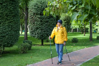 Kiev, Ukrayna - 9 Eylül 2020: İskandinav yürüyüşü - genç bir kadın mavi gökyüzünün arka planında yürüyüşe çıkıyor.