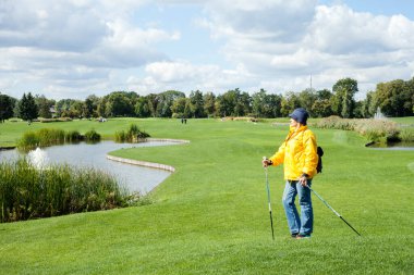 KIEV, UKRAINE - SEPTEMBER 09, 2020: Sarı yağmurluk ve mavi şapkalı bir kadının belinin portresi.