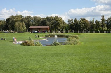 KIEV, UKRAINE - 09 Eylül 2020: insanlar göl kenarındaki golf sahasında dinleniyor