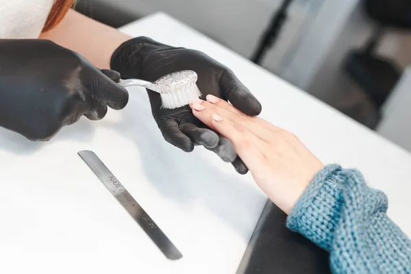 Manicurista elimina el polvo con un cepillo — Foto de Stock