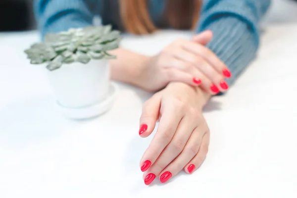 Крупный план рук молодой женщины с красным маникюром — стоковое фото