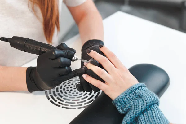 The manicurist removes the old cover from the nail — Stock Photo, Image