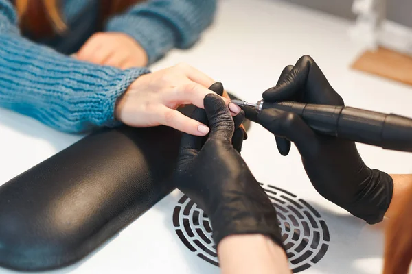 The manicurist removes the old varnish coating from the clients nail — Stock Photo, Image