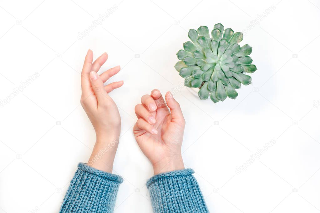 Closeup of hands of a young woman with manicure on nails against white background