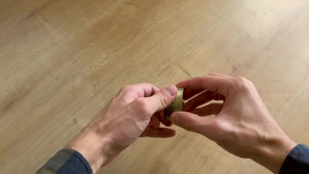 Caucasian male hands grinding medical marijuana in a small gold grinder — Stockvideo