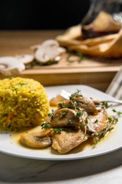 Sağlıklı fırında İtalyan tavuğu marsalası, sarı pirinç ve mantarlı.