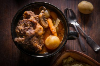 Potjiekos Güney Afrika kuyruklu güveç bebek altın patates havuç ve düğme mantar ile