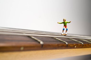 Minyatür kaykay figürler makro closeup gitar dizeleri aşağı öğütmek