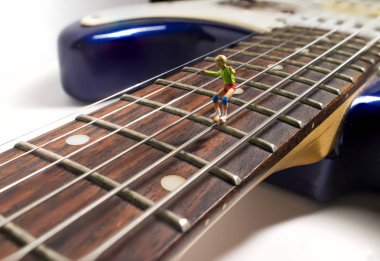 Minyatür kaykay figürler makro closeup gitar dizeleri aşağı öğütmek