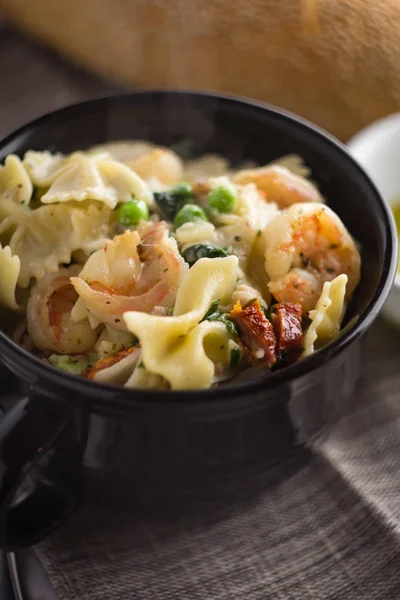 Kom Van Garnalen Farfalle Alfredo Met Erwten Spinazie Zongedroogde Tomaten — Stockfoto