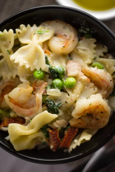 Kom Van Garnalen Farfalle Alfredo Met Erwten Spinazie Zongedroogde Tomaten — Stockfoto