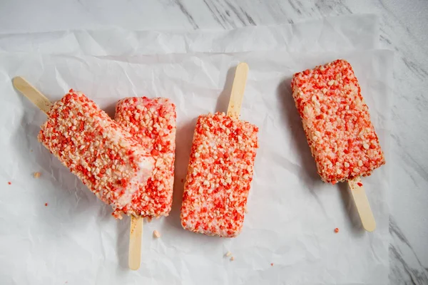 Strawberry shortcake ice cream bars with cake crumbles