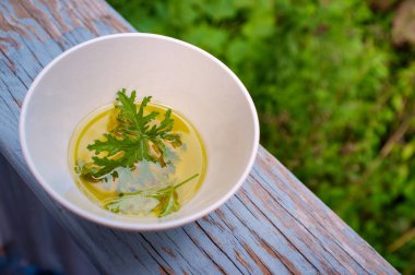 Ev yapımı sivrisinek kovucu yapmak için yağın içinde dinlenen bir sitronella yaprağı.