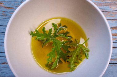 Ev yapımı sivrisinek kovucu yapmak için yağın içinde dinlenen bir sitronella yaprağı.