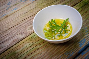 Ev yapımı sivrisinek kovucu yapmak için yağın içinde dinlenen bir sitronella yaprağı.