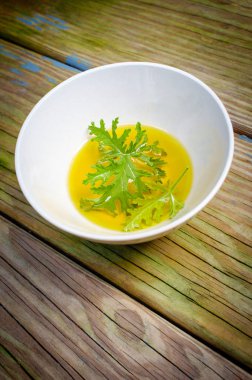 Ev yapımı sivrisinek kovucu yapmak için yağın içinde dinlenen bir sitronella yaprağı.