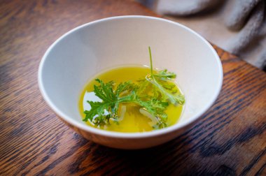 Ev yapımı sivrisinek kovucu yapmak için yağın içinde dinlenen bir sitronella yaprağı.