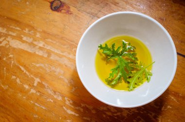 Ev yapımı sivrisinek kovucu yapmak için yağın içinde dinlenen bir sitronella yaprağı.