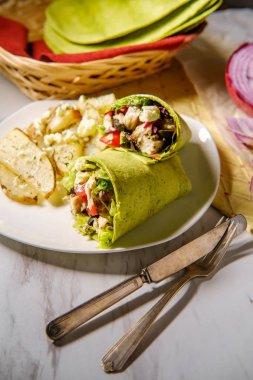 Patatesli ve peynirli sağlıklı Yunan tavuk dürümü.