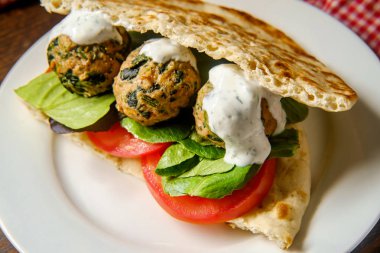 Dereotlu yoğurt soslu pide üzerine Akdeniz hindili köfteli sandviç.