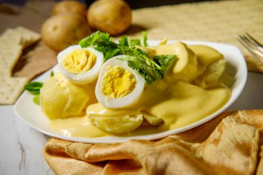 Papa a la Huancaina Peruvian potatoes and hard boiled eggs with spicy aji amarillo yellow sauce clipart