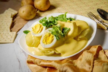 Papa a la Huancaina Peruvian potatoes and hard boiled eggs with spicy aji amarillo yellow sauce clipart