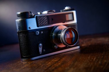 Antika film kamera karanlık moody aydınlatma ile rustik masada