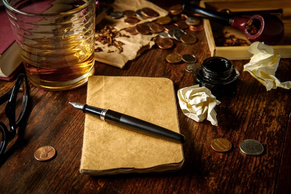 ペンとインクのウイスキーパイプとグラスを持つ作家の机 — ストック写真