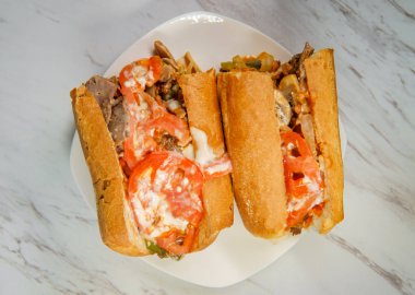 Dilimlenmiş domatesli ve bol kremalı peynirli peynirli peynirli sandviç.