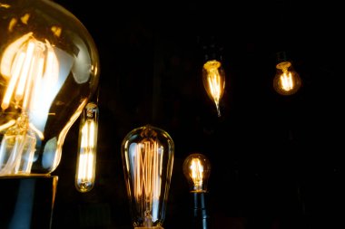 Birçok dekoratif antika edison tarzı ampuller asılmış.